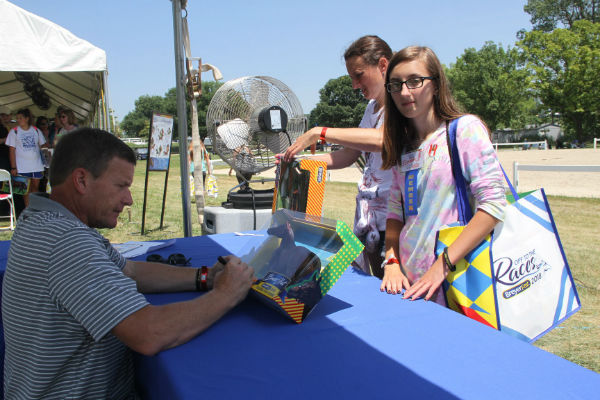 Brass Hat's trainer Buff Bradley signs a Brass Hat Breyer for a fan