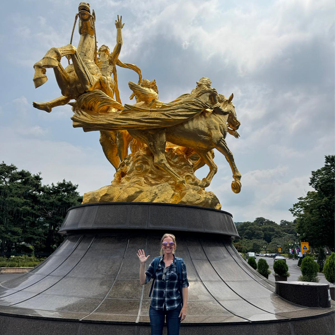 Photo from CJ's trip to South Korea - Day 2 (CJ pictured with gold statue waving)